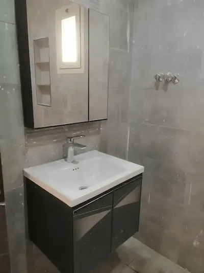 فني صحي في الكويت يقوم بإصلاح تسريبات المياه